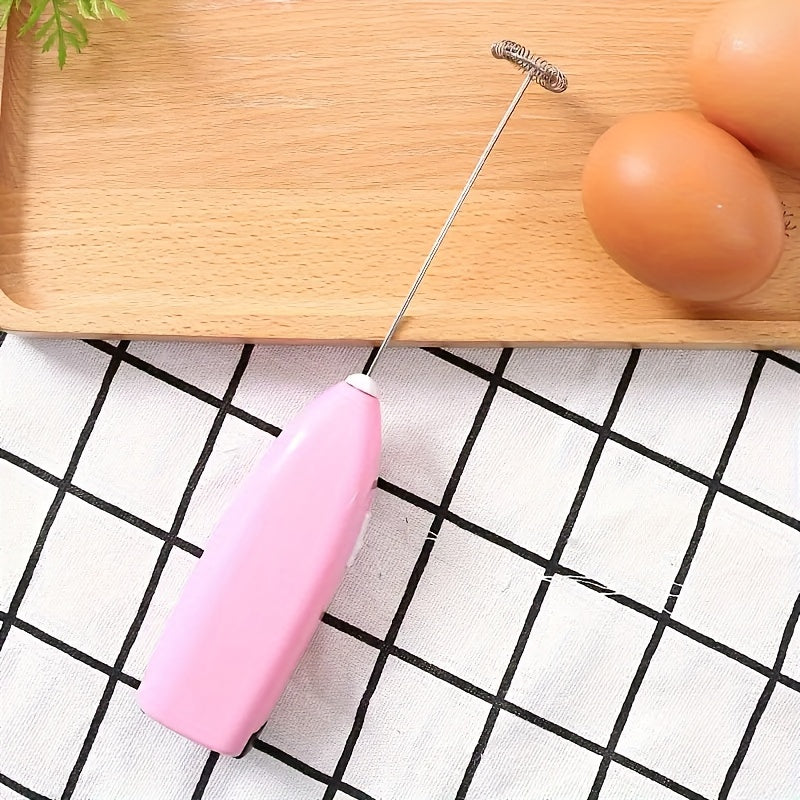 Pink kitchen whisk on a checkered tablecloth with eggs and a wooden board in the background