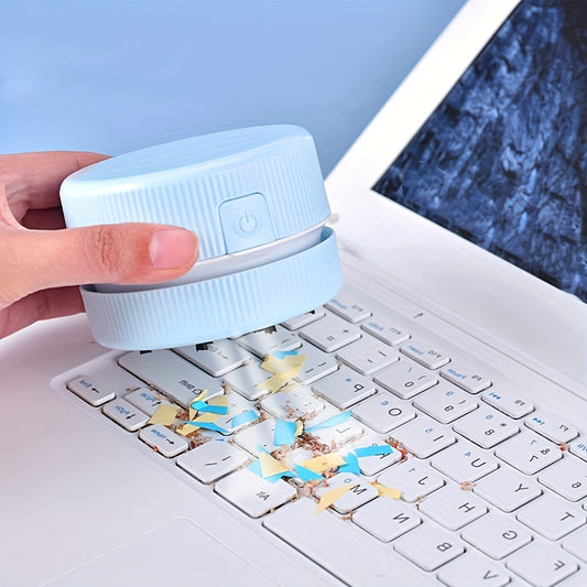 Person using a small device to clean a laptop keyboard with debris collected on it.