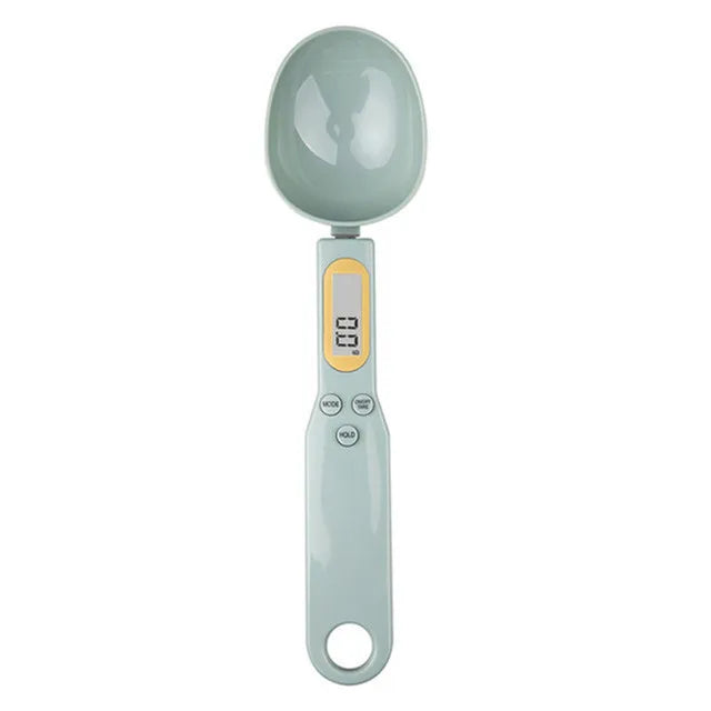 Digital measuring spoon with a light green handle and gray spoon head on a white background