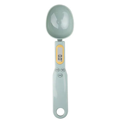 Digital measuring spoon with a light green handle and gray spoon head on a white background