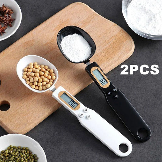 Two digital measuring spoons on a wooden cutting board with ingredients.