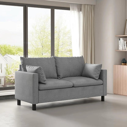 Gray sofa in a modern living room with large windows and a wooden cabinet.