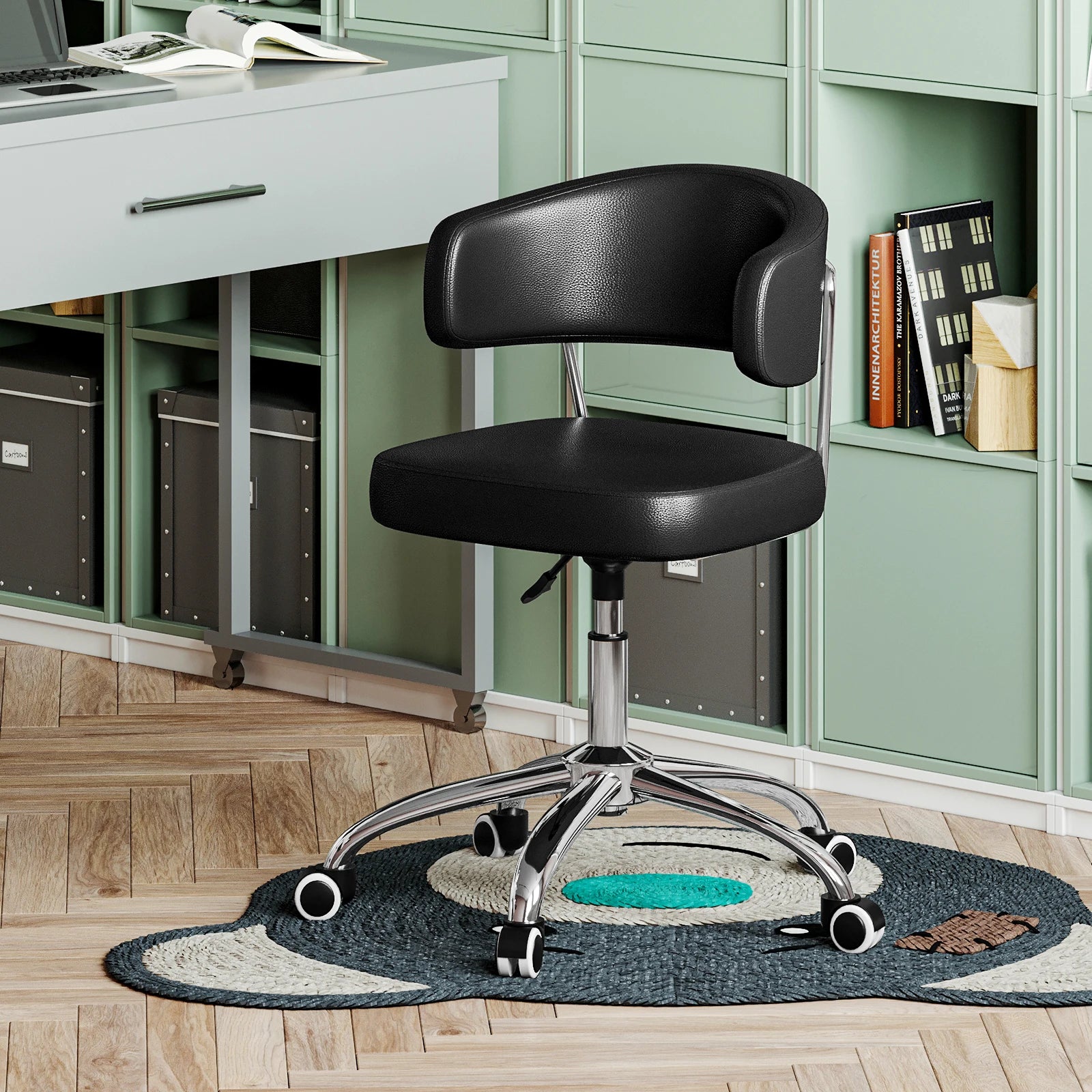 Black office chair in a home office setting with green cabinets and a desk.