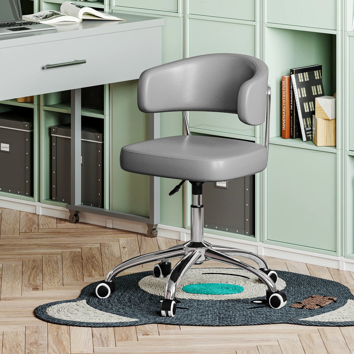 Gray office chair in front of a desk with a green bookshelf in the background.