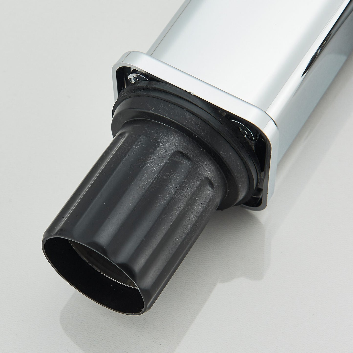 Close-up of a black exhaust pipe on a white background