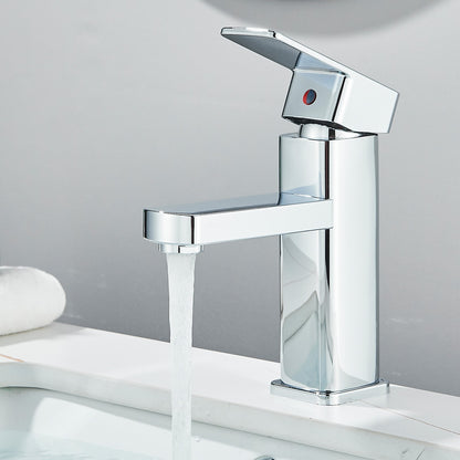 Chrome faucet with water flowing on a white surface and gray background