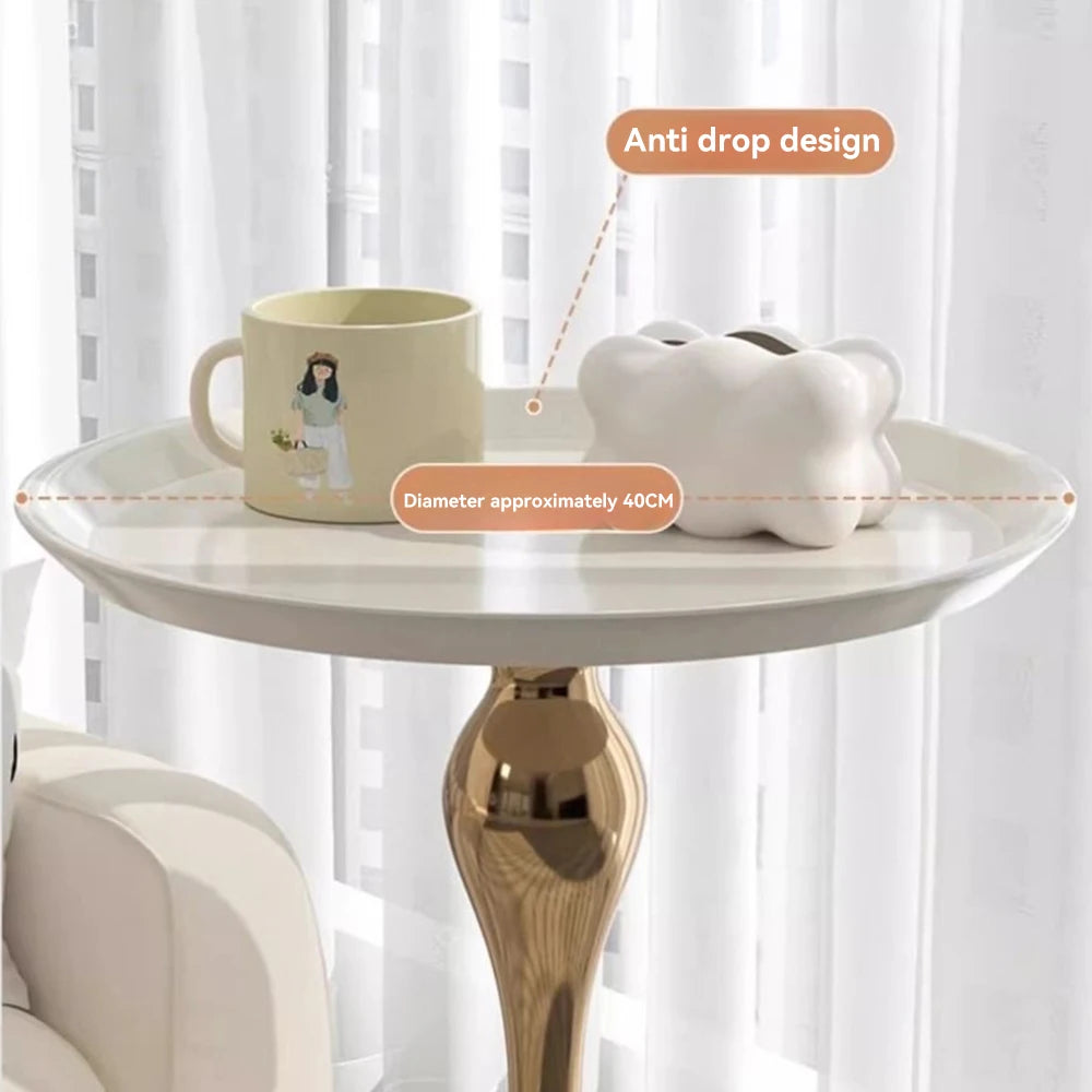 Small round table with a mug and piggy bank on top, against a white curtain background.