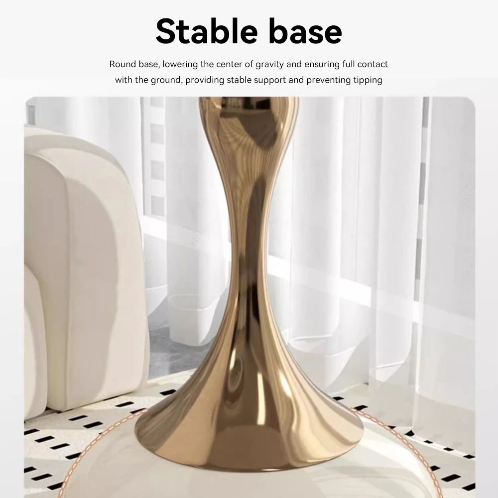 Gold table base with text on stability, placed on a white surface with a blurred background.