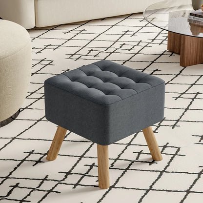 Gray upholstered stool with wooden legs on a patterned rug