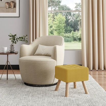Beige armchair with a yellow ottoman in a living room setting with large windows.