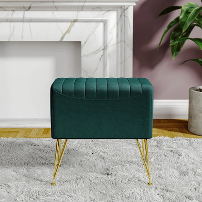 Green ottoman with gold legs in a room with a fireplace and plant