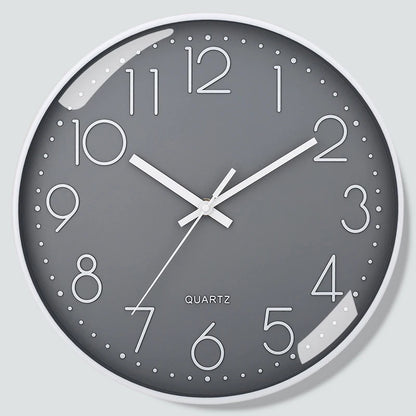 Grey wall clock with white numbers and hands on a light grey background
