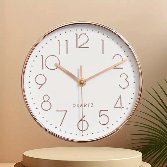 Round wall clock with rose gold frame and hands on a beige background