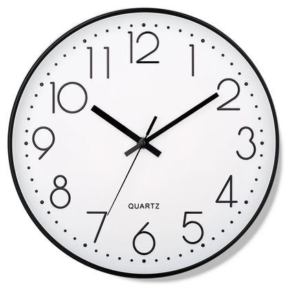 Round wall clock with black frame and white face displaying the time.