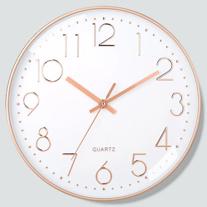 Wall clock with rose gold frame and numerals on a light gray background