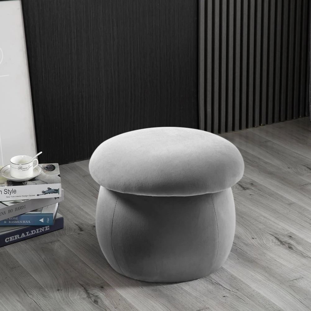 Gray mushroom-shaped stool on a wooden floor with books and a cup in the background.