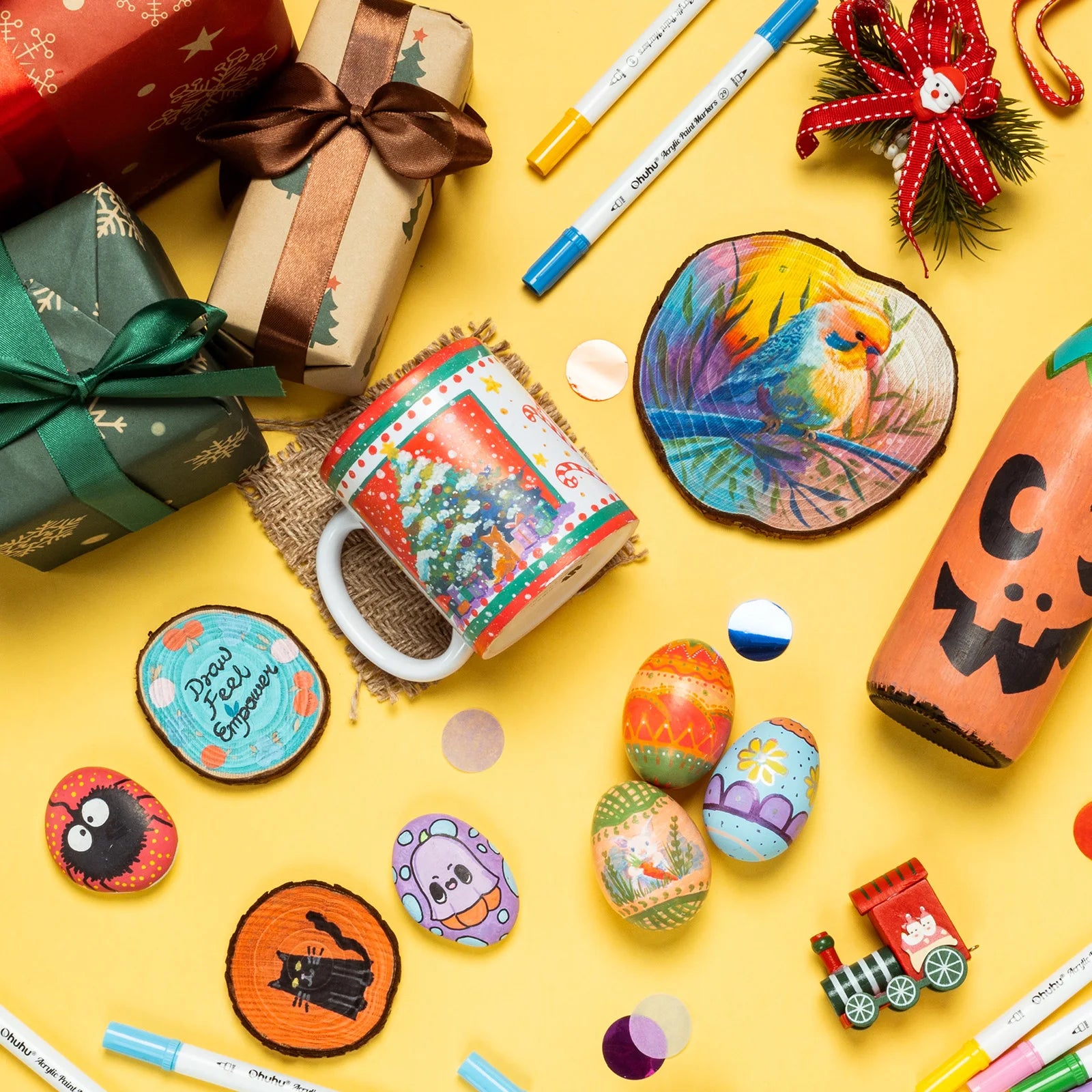 Colorful Christmas-themed items including mugs, coasters, and decorative stones on a yellow background.