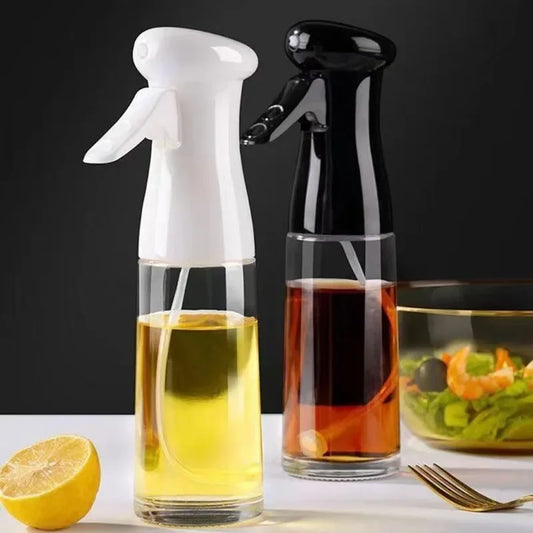 Two spray bottles filled with liquids on a table with a salad and lemon.