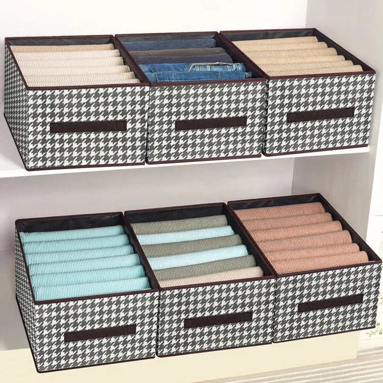 Black and white checkered storage boxes with compartments on a shelf.