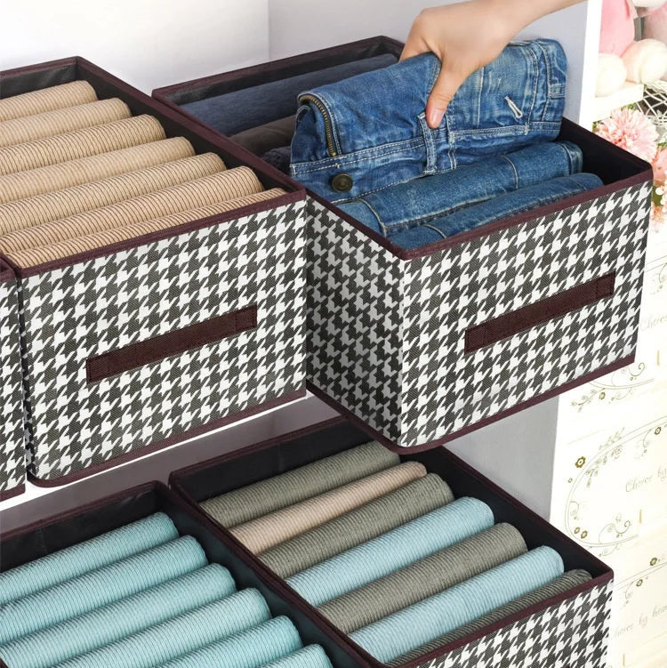 Storage bins with houndstooth pattern being used to organize clothes.