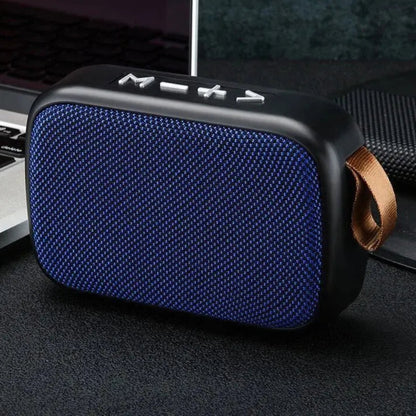 Blue portable speaker with a brown strap on a dark surface