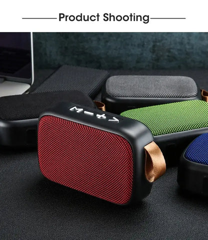 Red portable speaker with a brown strap on a dark surface