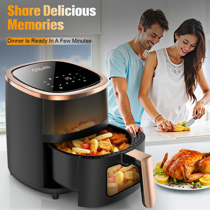 Black air fryer with food inside, couple preparing dinner in the background