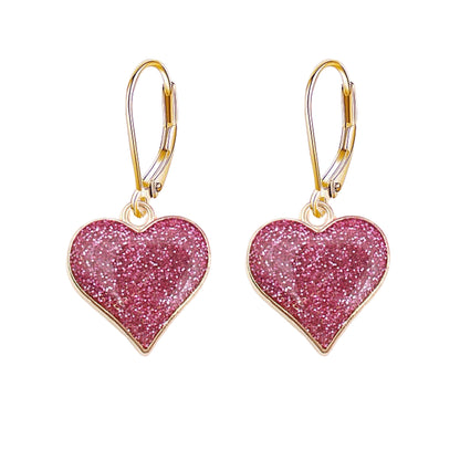 Heart-shaped earrings with pink glittery centers and gold hooks on a white background