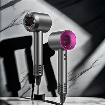 Silver and pink hair dryer on a marble surface with blurred background