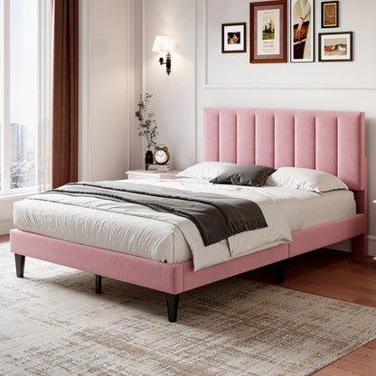 Pink upholstered bed in a bedroom with framed pictures on the wall.