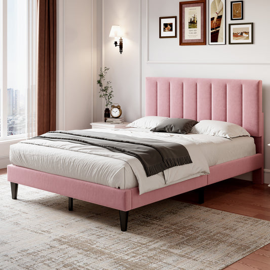 Pink upholstered bed in a bedroom with framed pictures on the wall.