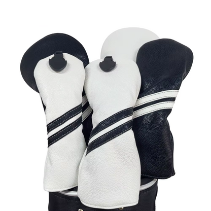 Three golf club head covers in black, white, and navy with striped patterns on a white background.
