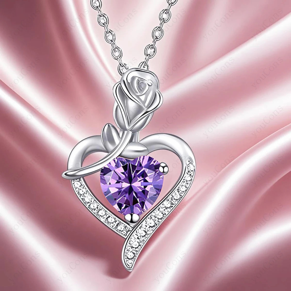 Silver rose-shaped pendant with a purple gemstone on a pink satin background