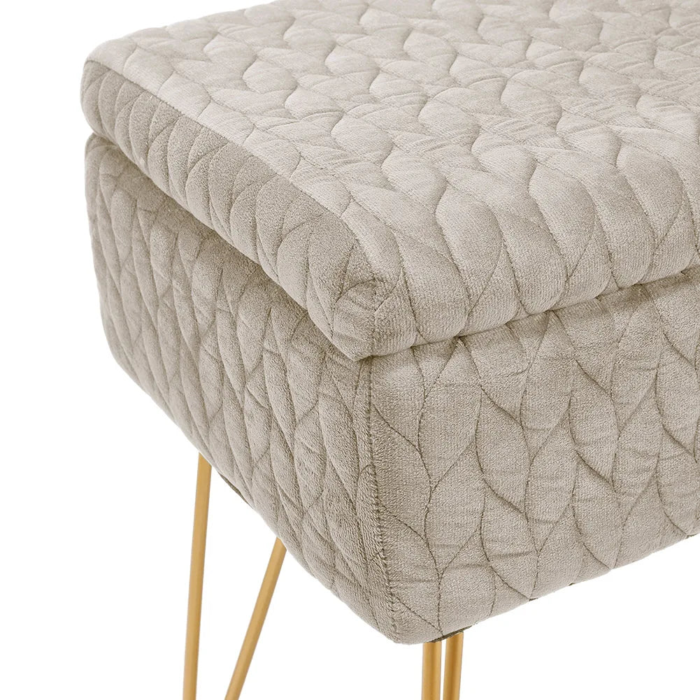 Quilted beige ottoman with gold legs on a white background
