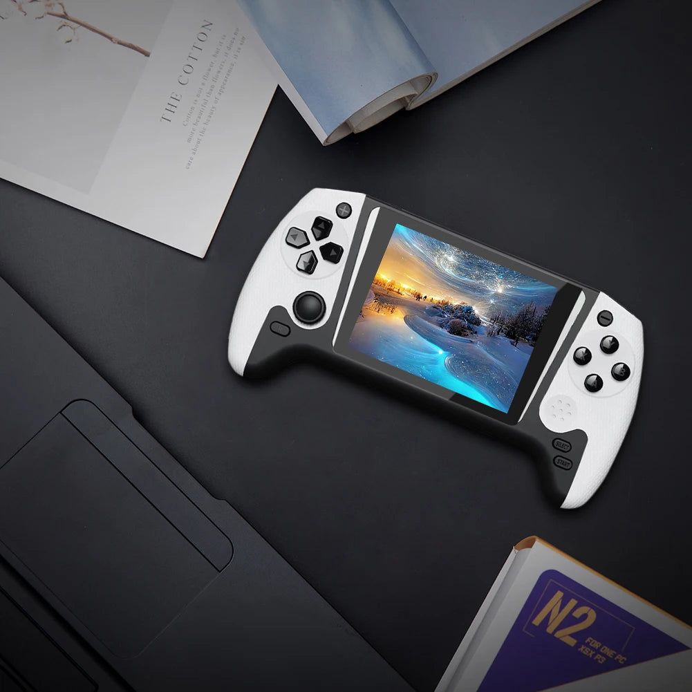 Handheld gaming console with a screen displaying a scenic image on a dark surface.