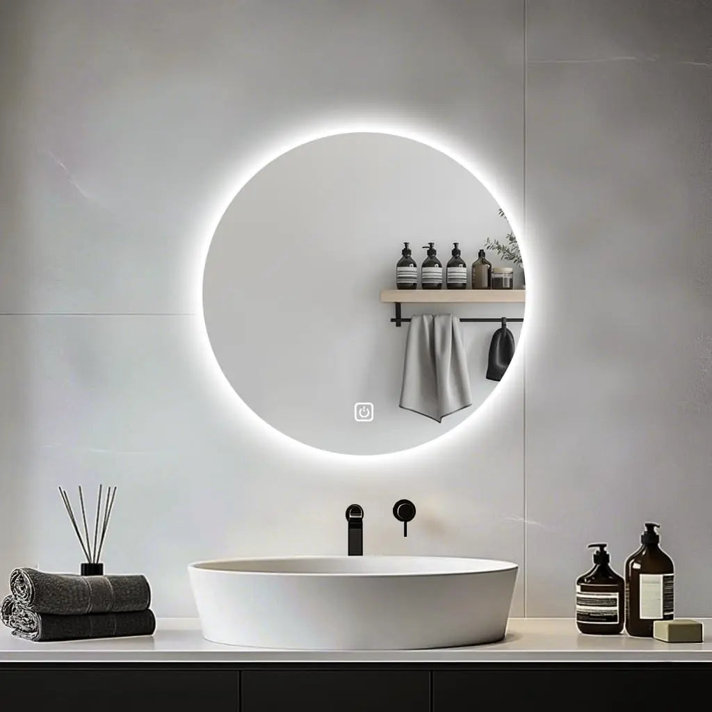 Modern bathroom with a round illuminated mirror, sink, and toiletries.