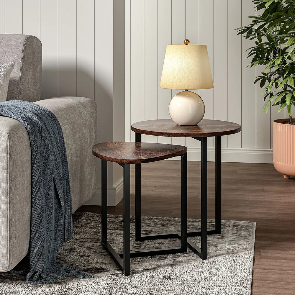 Two wooden side tables with a lamp on a gray sofa in a living room setting.