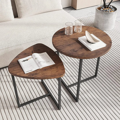 Two wooden side tables with a magazine and glasses on a light-colored floor.