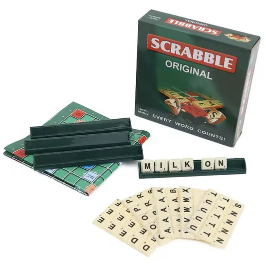 Scrabble Original game set on a white background, including the dark green box, a green playing board, four dark green tiles, a row of letter tiles spelling 'MILK ON', and a fan of letter tiles.