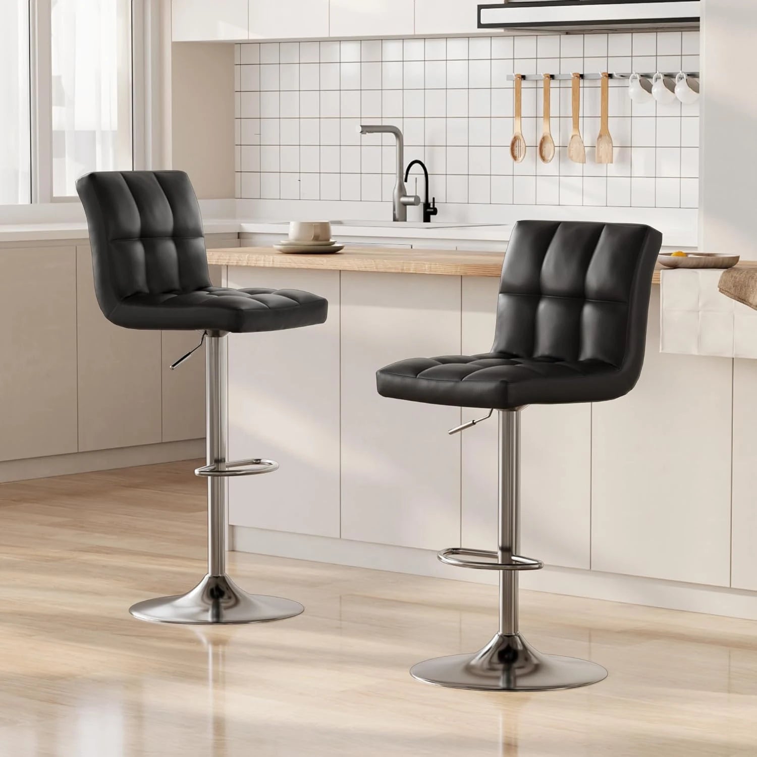 Two black bar stools in a kitchen setting with wooden countertops and white tiled walls.