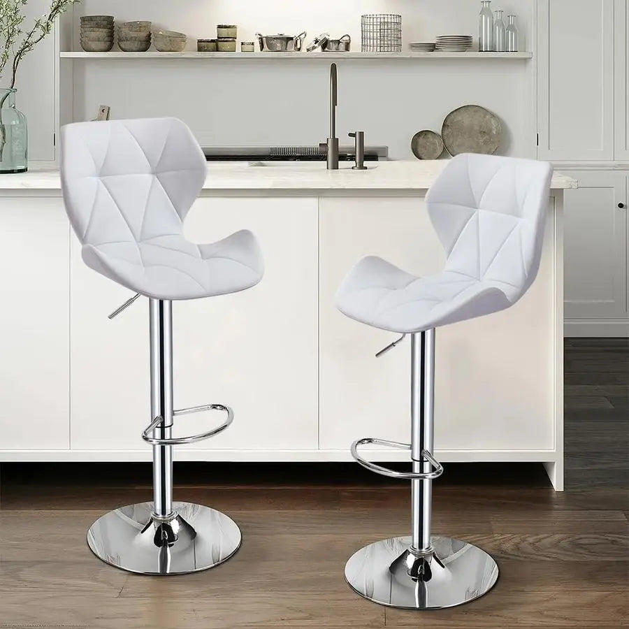 Two white quilted bar stools with chrome bases in a kitchen setting.