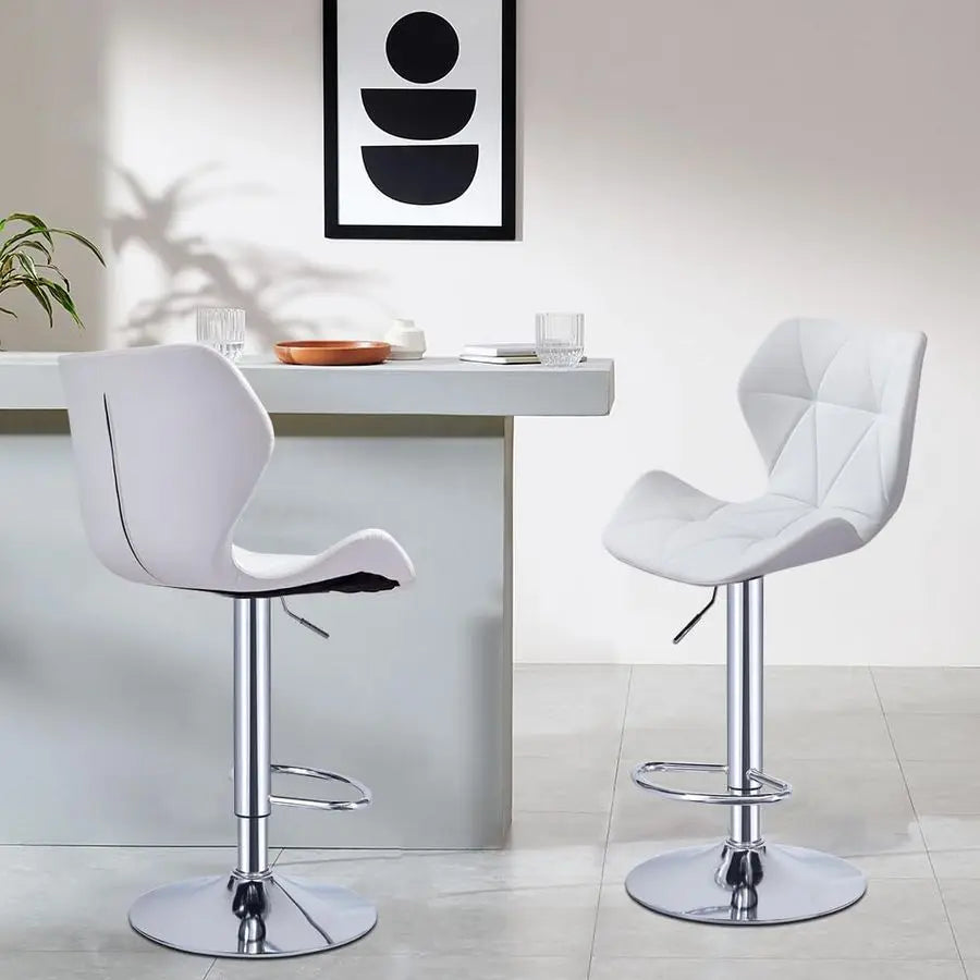 Two white bar stools in front of a white table with a modern abstract painting on the wall.