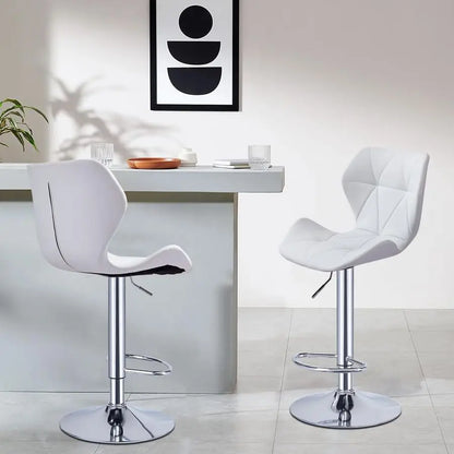 Two white bar stools in front of a white table with a modern abstract painting on the wall.