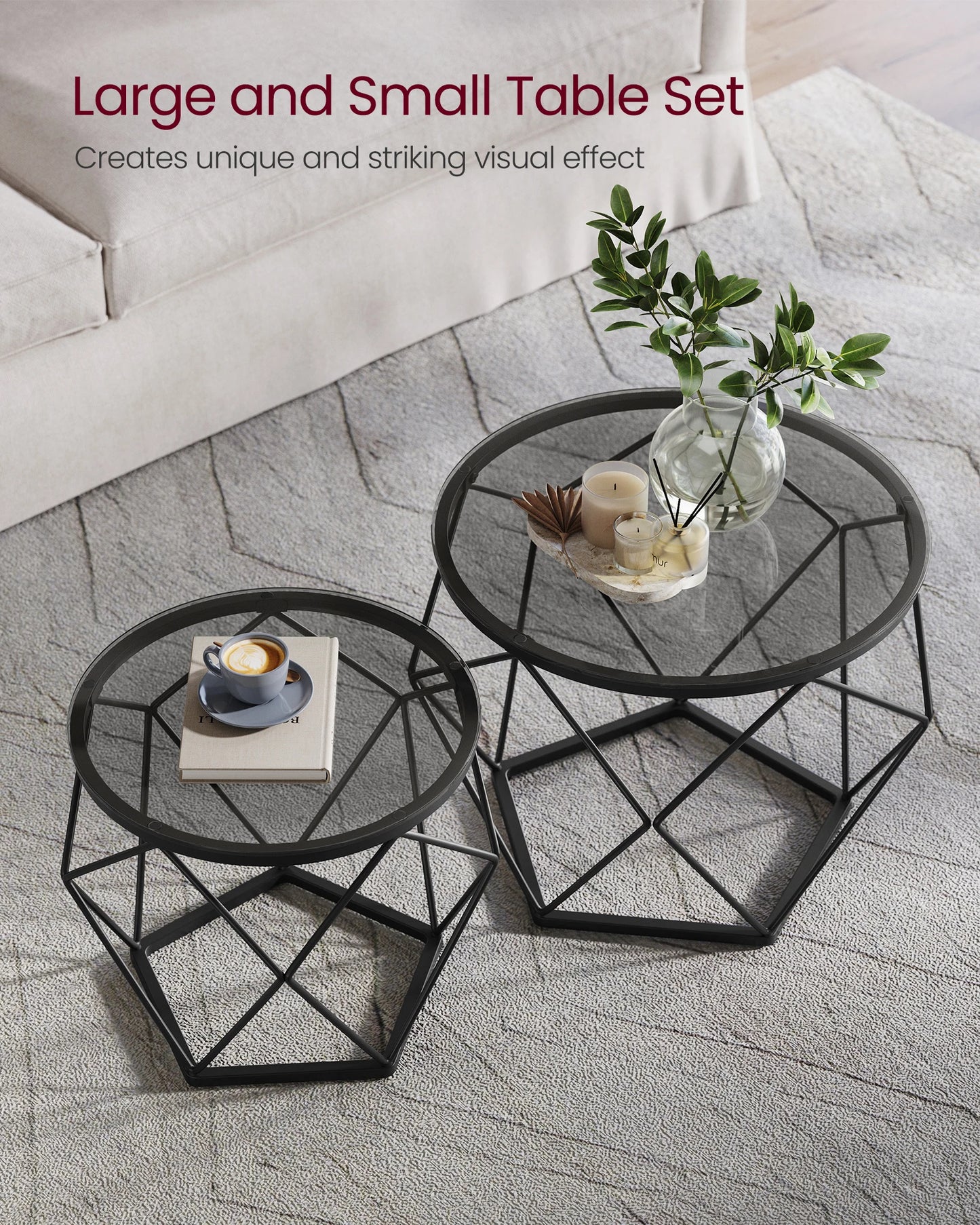 Two black metal tables with decorative items on a stone floor.