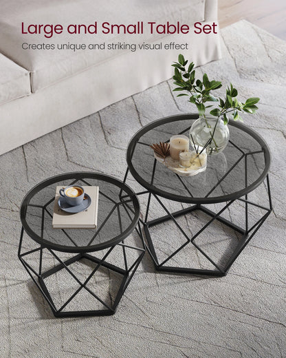 Two black metal tables with decorative items on a stone floor.