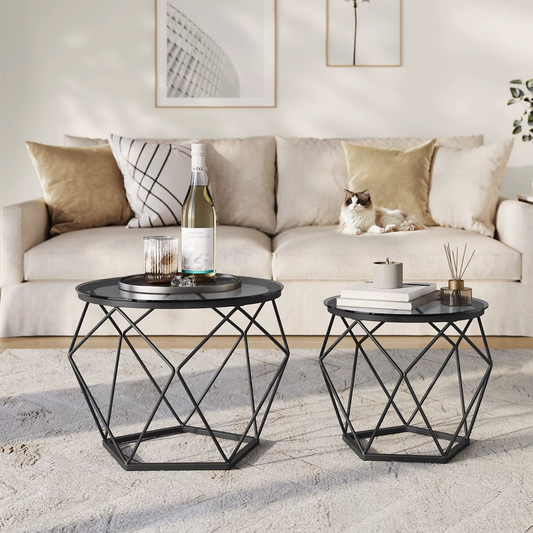 Two black geometric side tables in a living room with a bottle of wine and glasses.