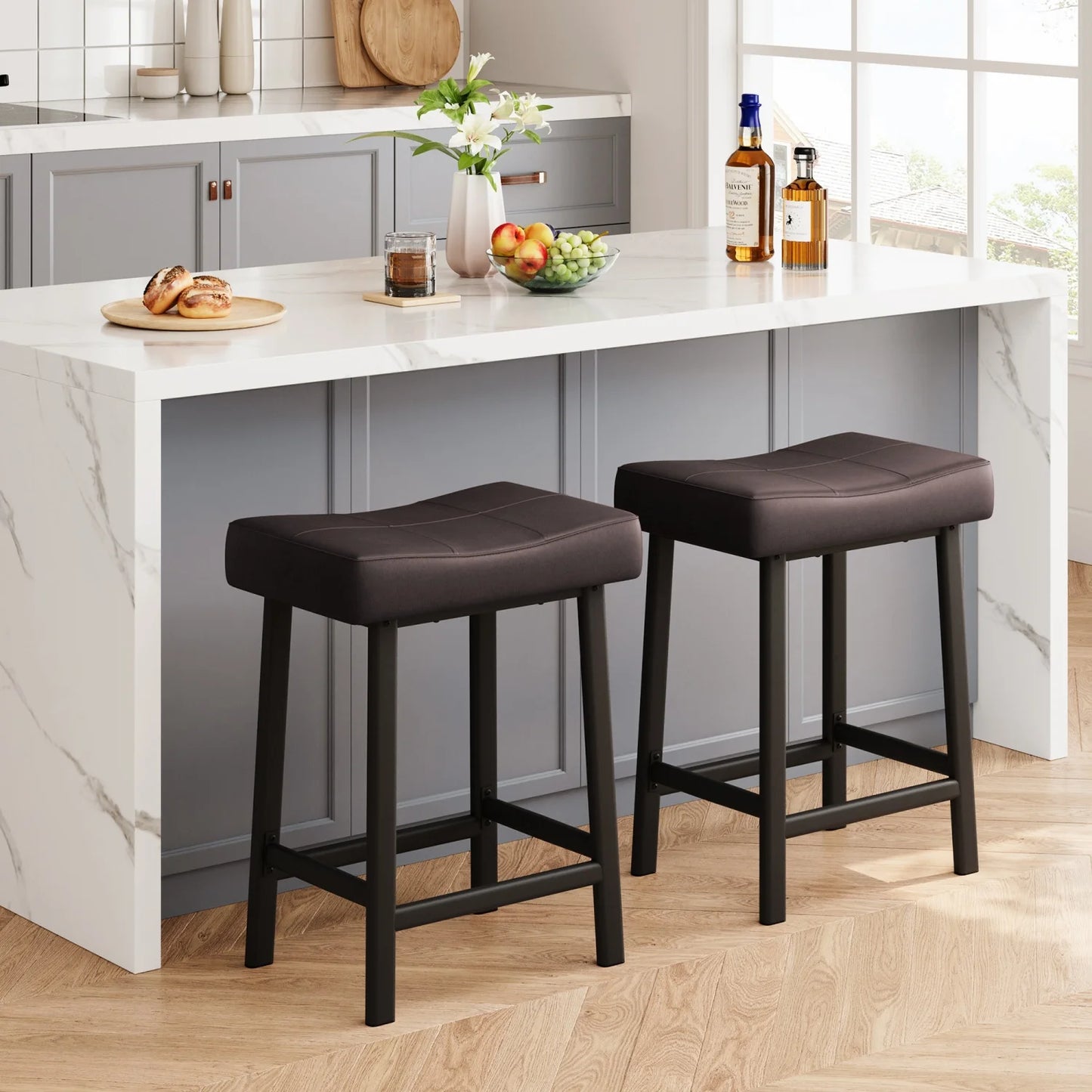 Two brown bar stools in front of a kitchen island with a marble countertop.