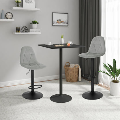 Two gray bar stools with black bases in a room with a small table and decor items.
