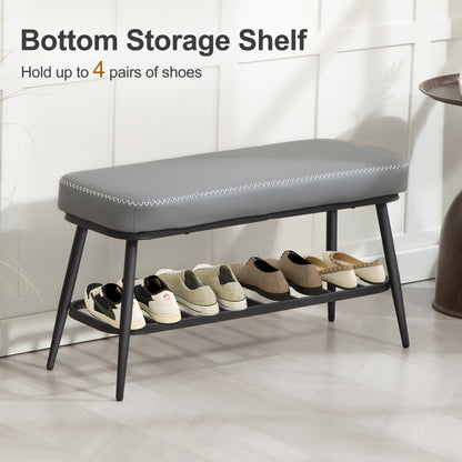 Gray shoe bench with storage shelf holding shoes against a white tiled wall.