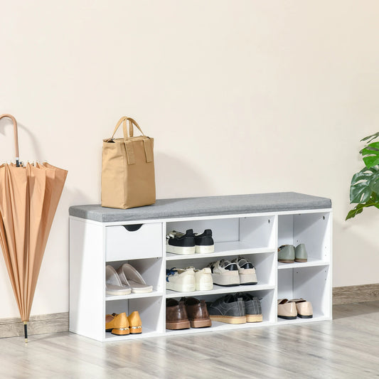 White shoe rack with gray top holding shoes, a bag, and an umbrella on a light wooden floor.